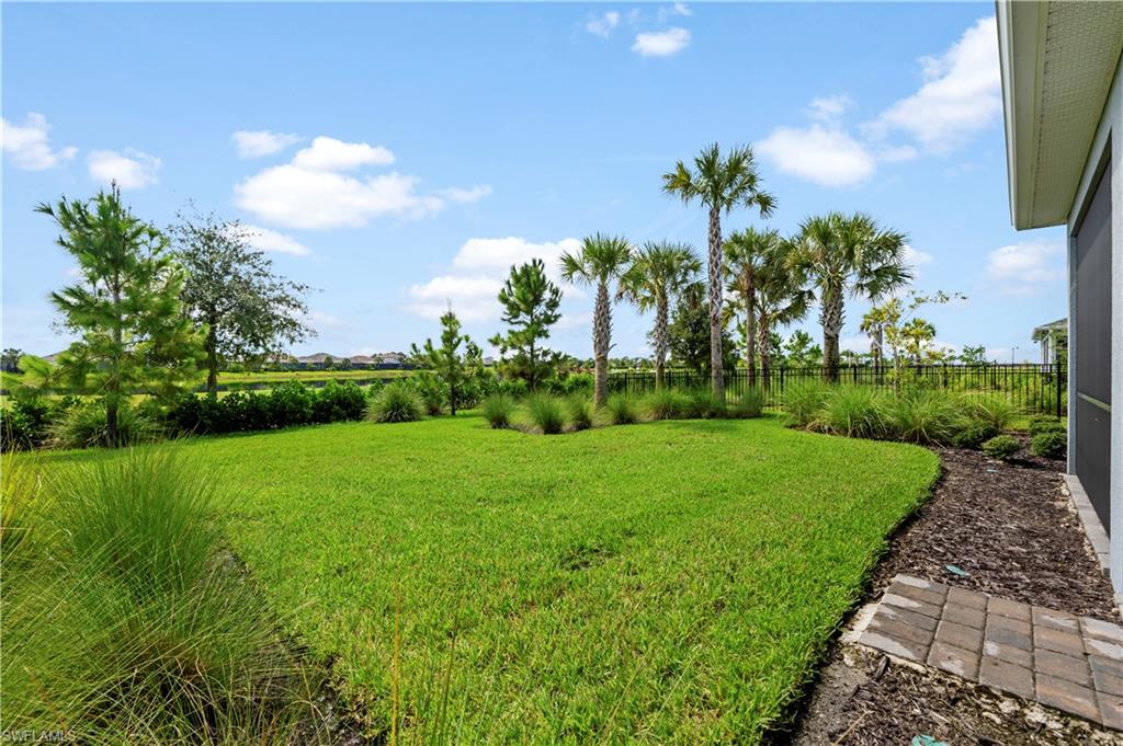Expansive green lawn with a black metal fence perimeter