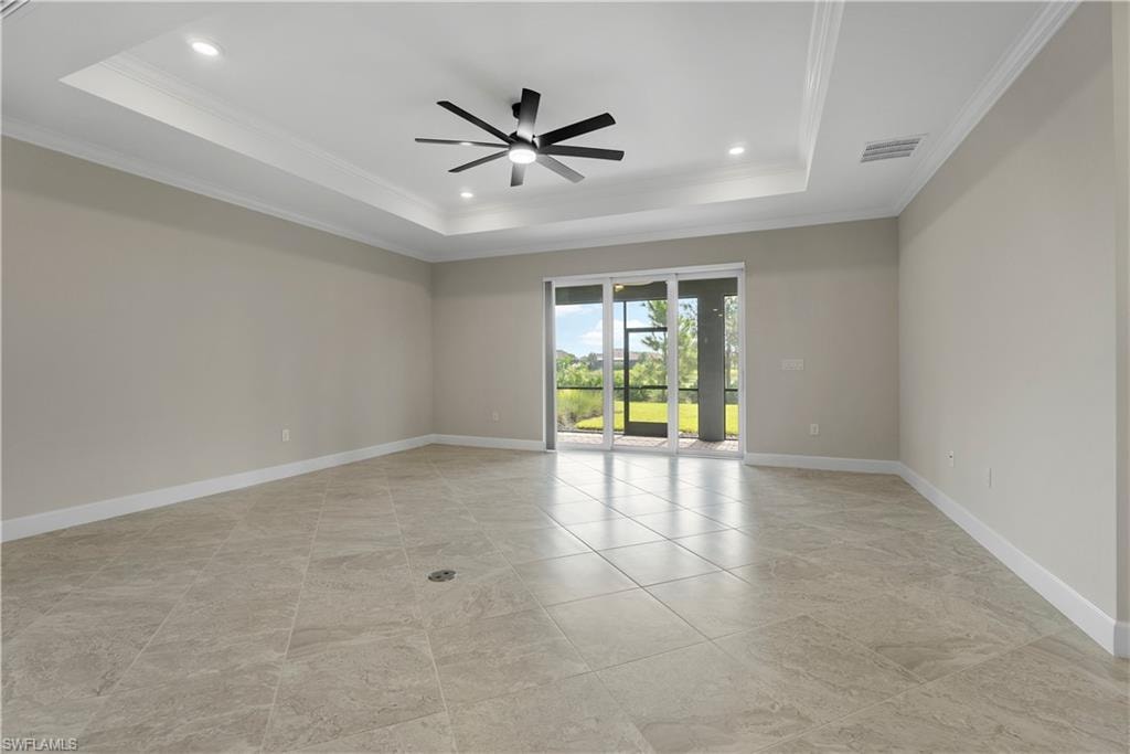 Tray ceiling with recessed lighting and a ceiling fan, tiled flooring, and sliding glass doors to an outdoor screened area
