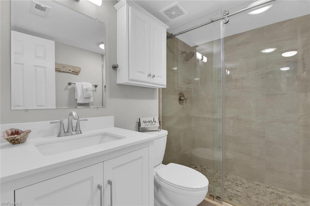 White vanity with integrated sink, chrome faucet, and quartz countertop