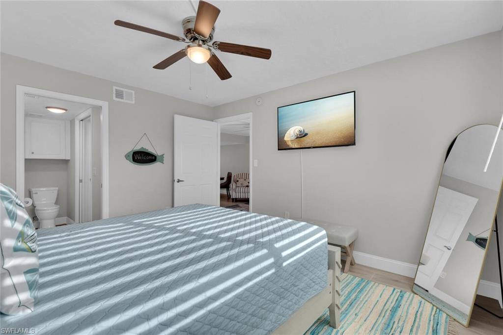 Ceiling fan with integrated lighting, light-toned wall color, white interior doors, and wood-finish flooring