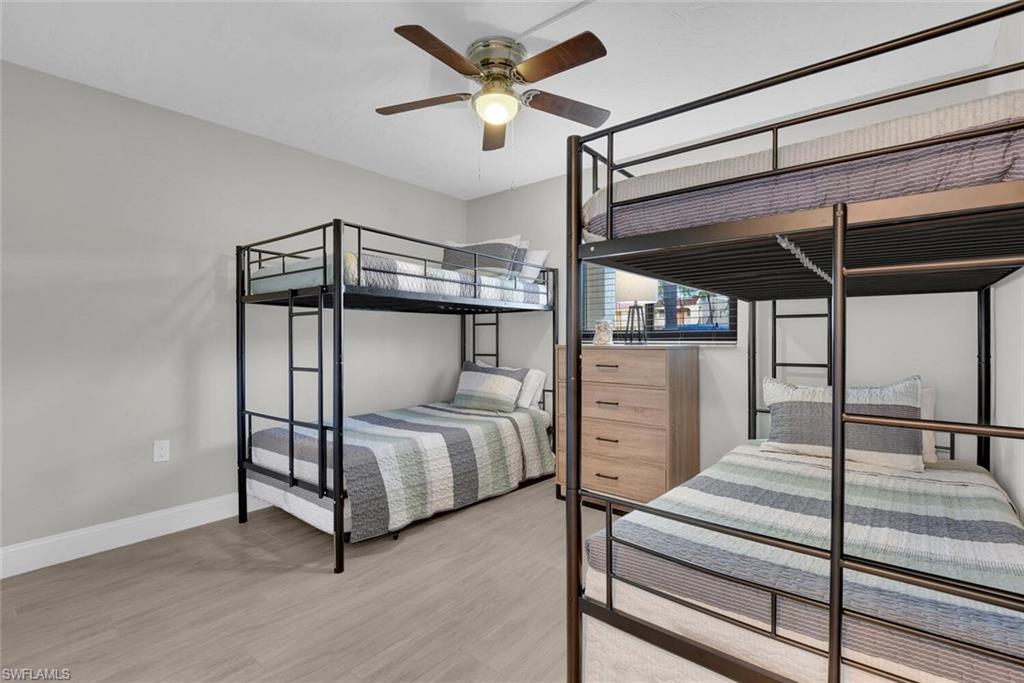 Recessed lighting, wood-finish flooring, ceiling fan with light fixture, window with blinds, and light-toned walls