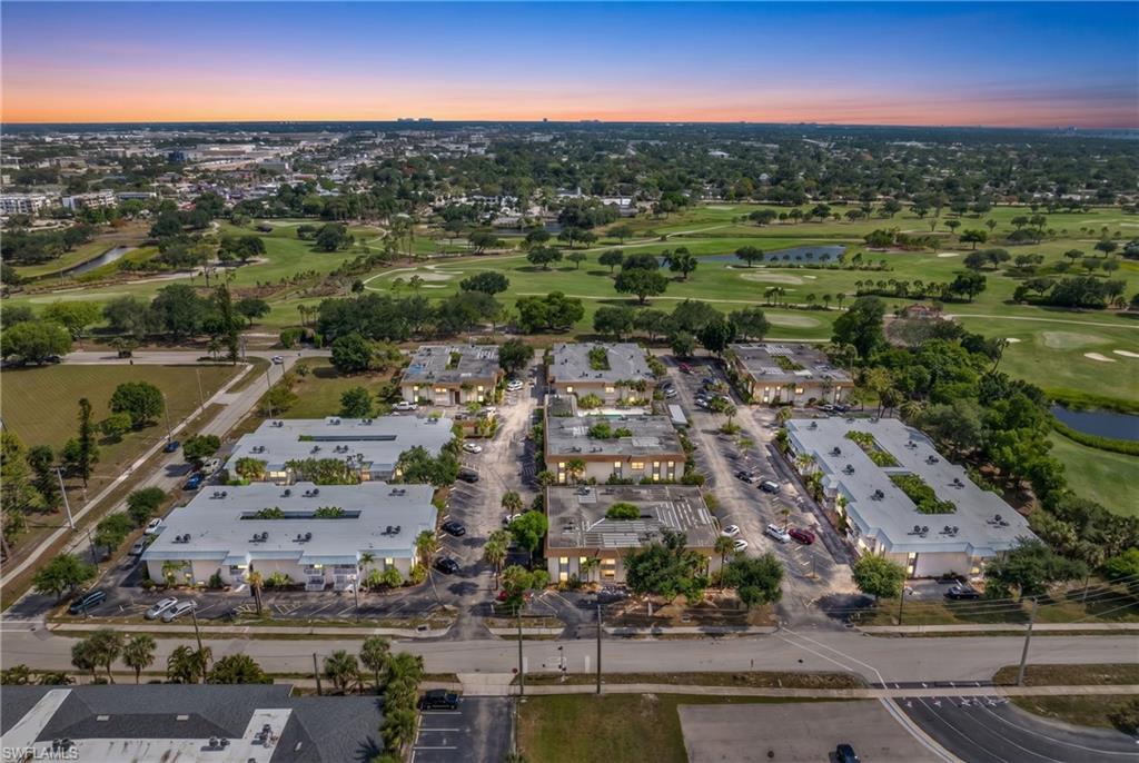 Expansive multi-building property with surrounding golf course, mature landscaping, and dedicated parking areas