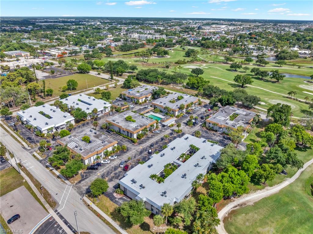 Multiple commercial buildings with flat roofs, surrounding a paved parking area