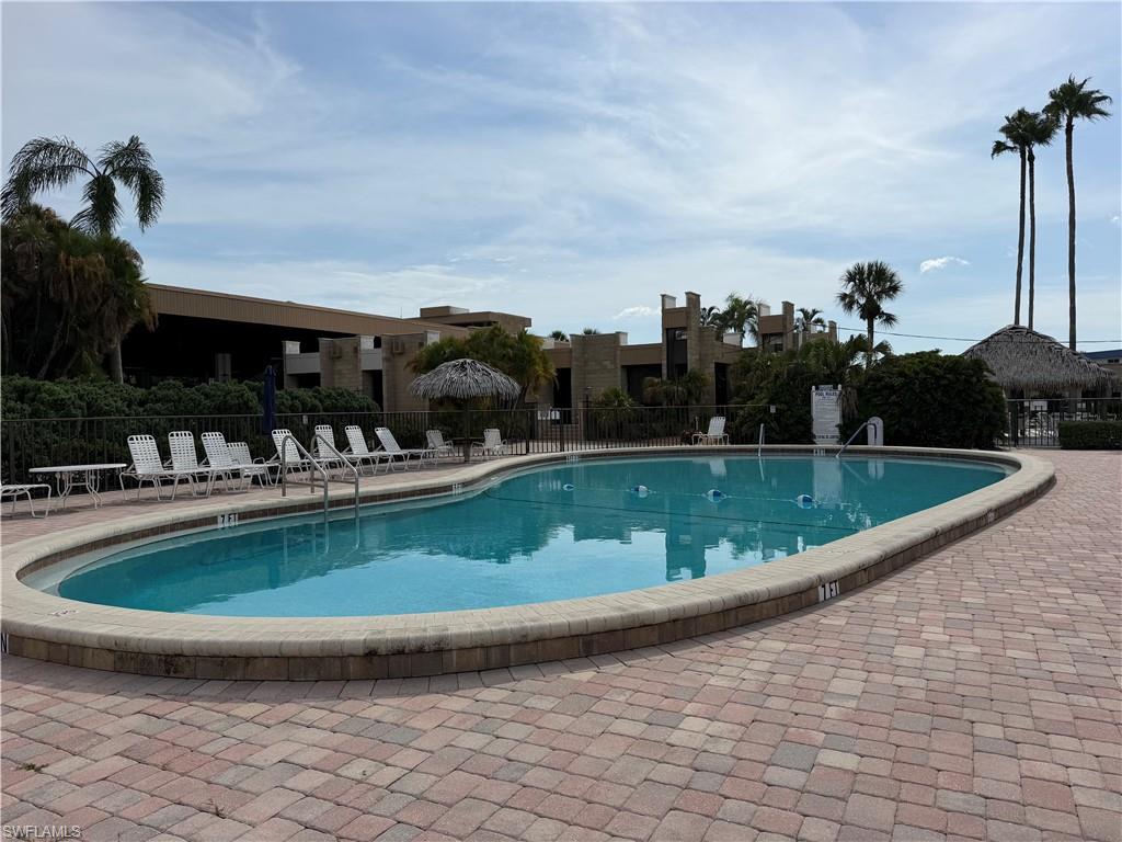 Curved swimming pool with a stone coping and a paver deck