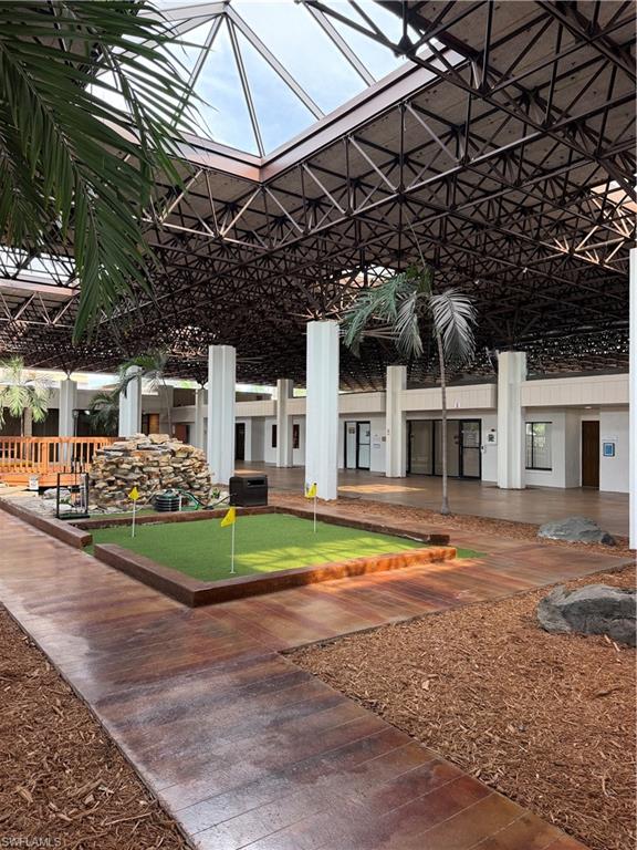 Expansive atrium featuring a large skylight, exposed structural beams, and concrete support columns