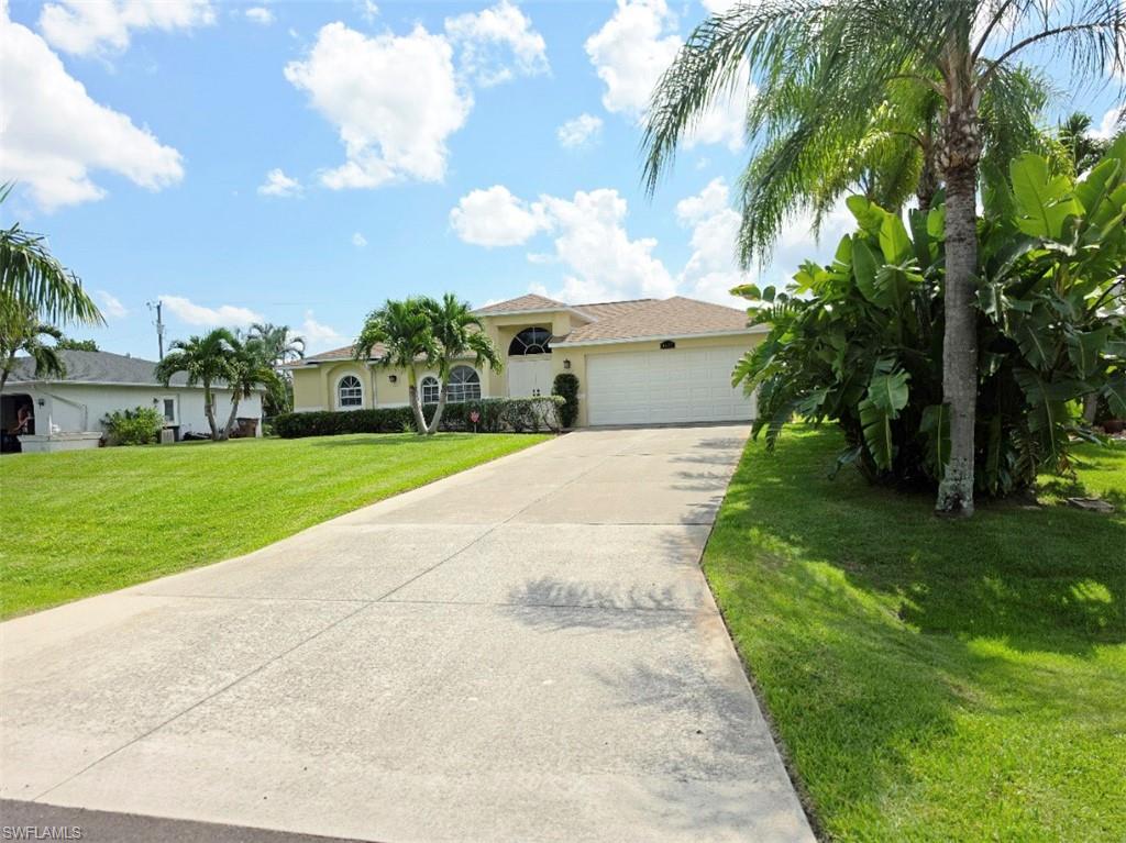 Spacious concrete driveway leading to a two-car garage