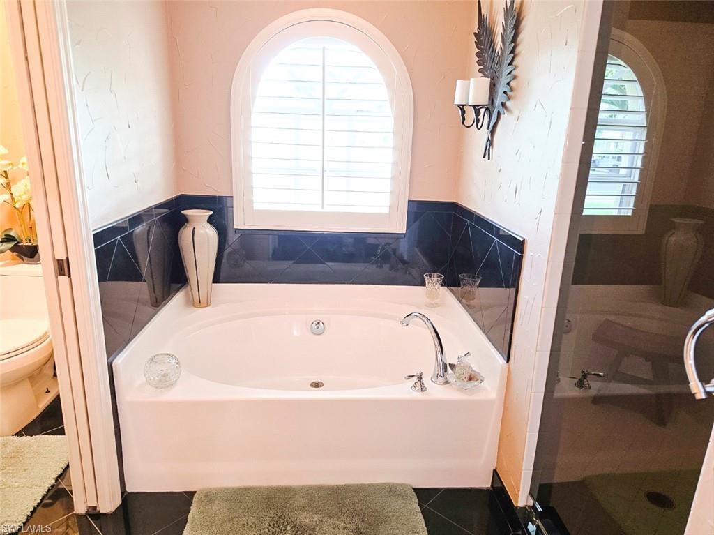 White vanity with panel-front cabinetry, dark stone-finish countertop, and integrated sink