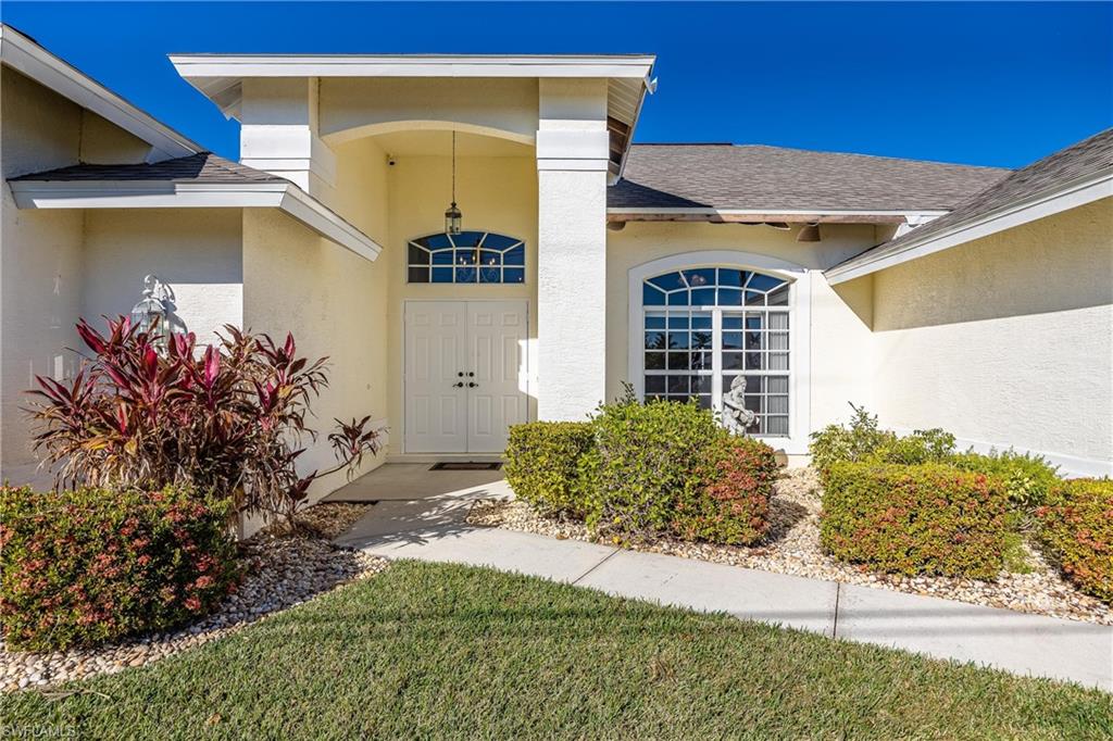 Property entrance with stucco siding and roof with shingles