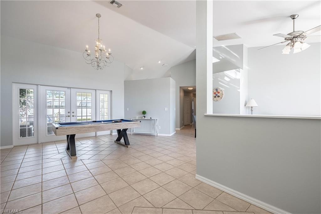 Rec room featuring baseboards, high vaulted ceiling, french doors, and light tile patterned floors