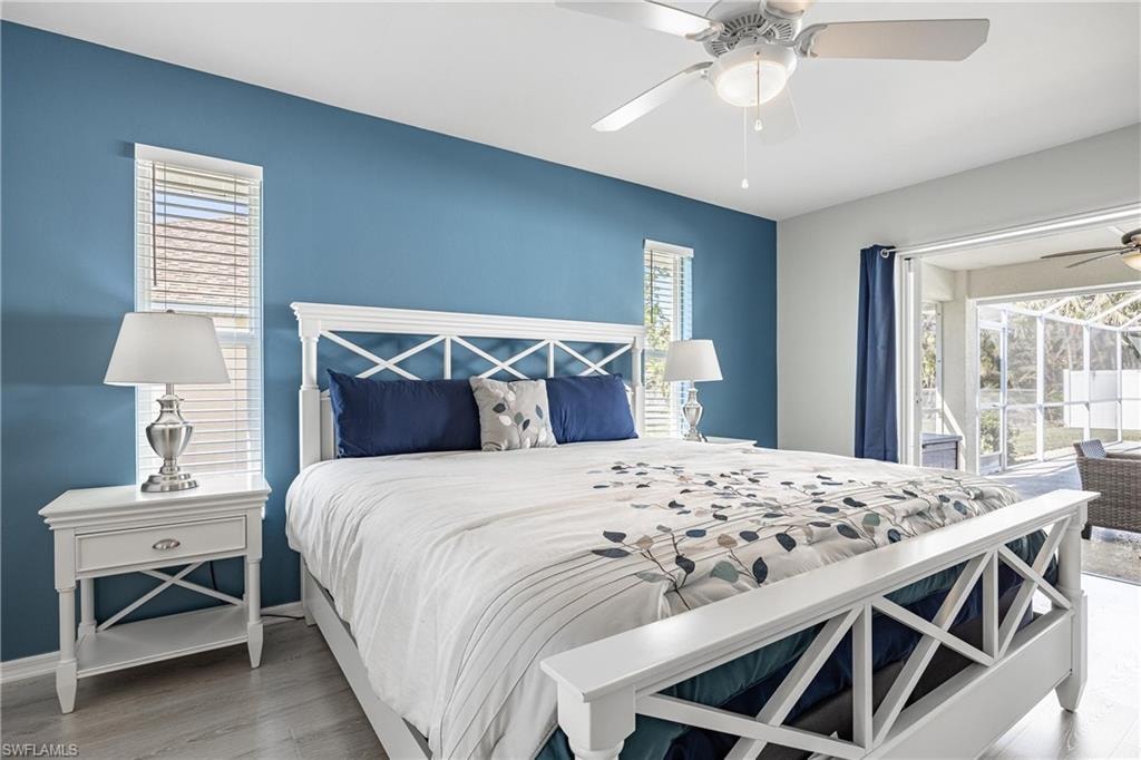 Bedroom with ceiling fan, baseboards, wood finished floors, and access to exterior
