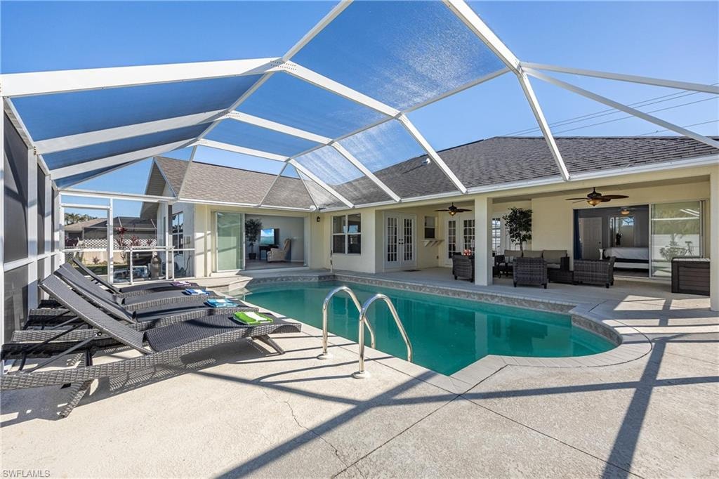 Outdoor pool with an outdoor hangout area, ceiling fan, french doors, a patio, and a lanai