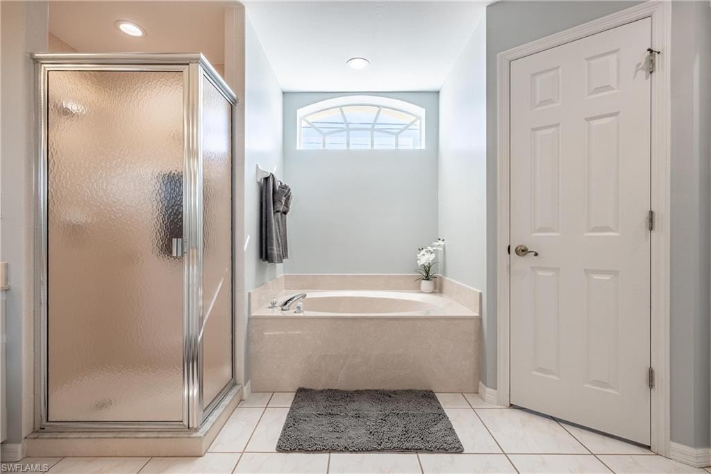 Full bath with a bath, tile patterned flooring, and a stall shower