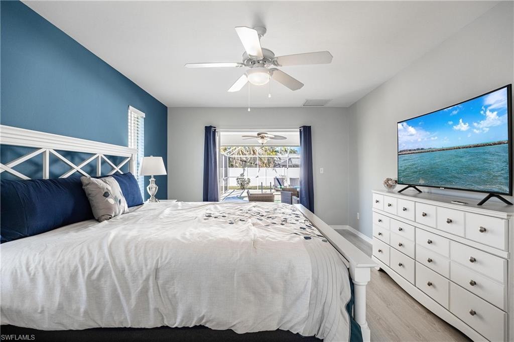 Bedroom with light wood-type flooring, visible vents, ceiling fan, and access to exterior