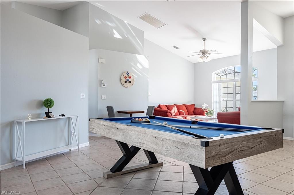 Recreation room featuring light tile patterned flooring, visible vents, lofted ceiling, a ceiling fan, and pool table