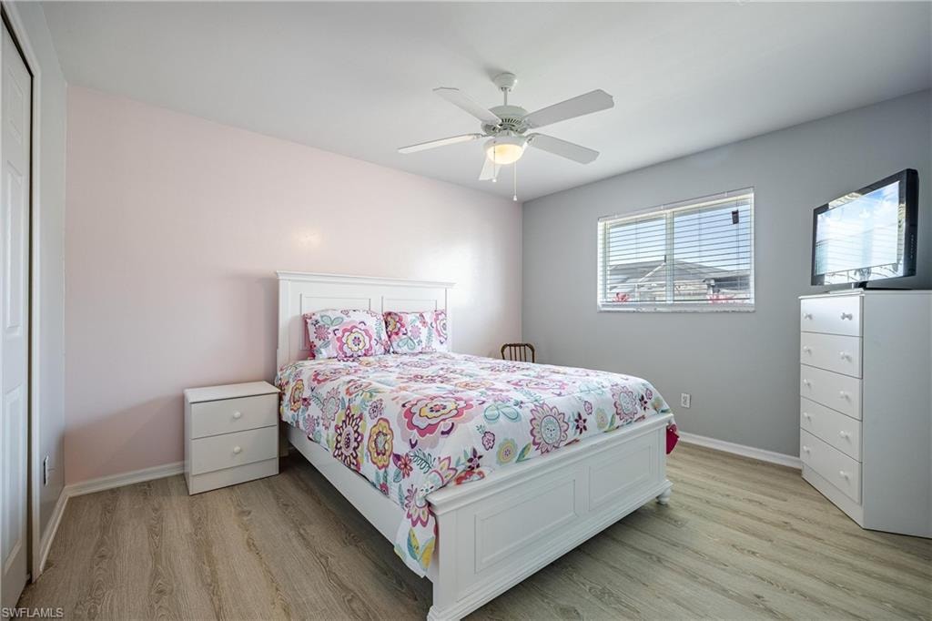 Bedroom featuring baseboards, a ceiling fan, and light wood-style floors
