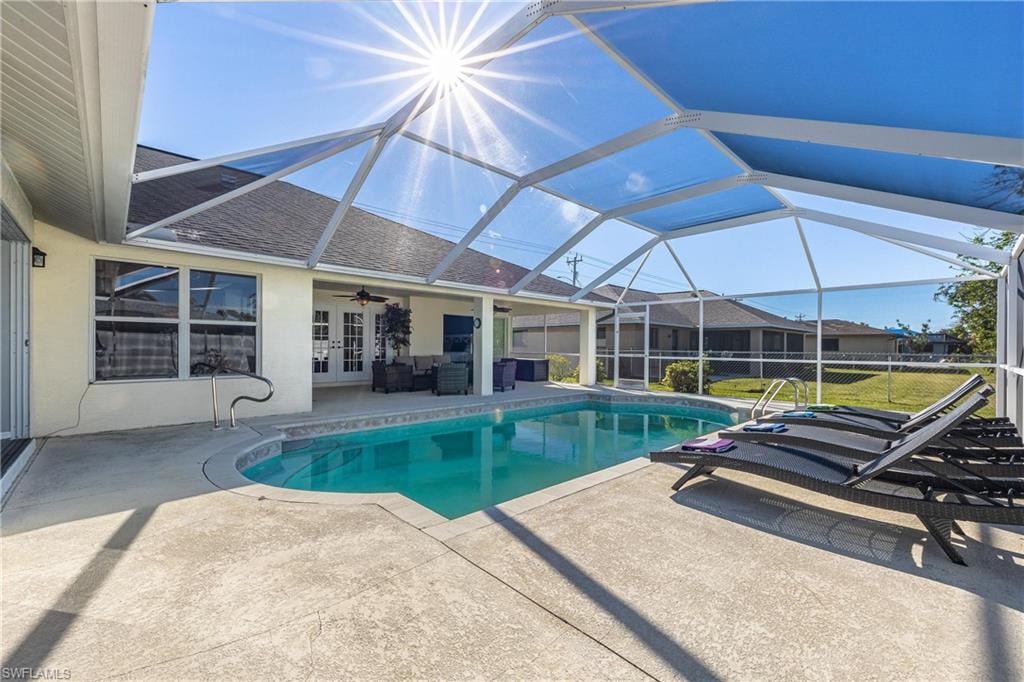 Pool featuring outdoor lounge area, ceiling fan, french doors, a patio, and a lanai