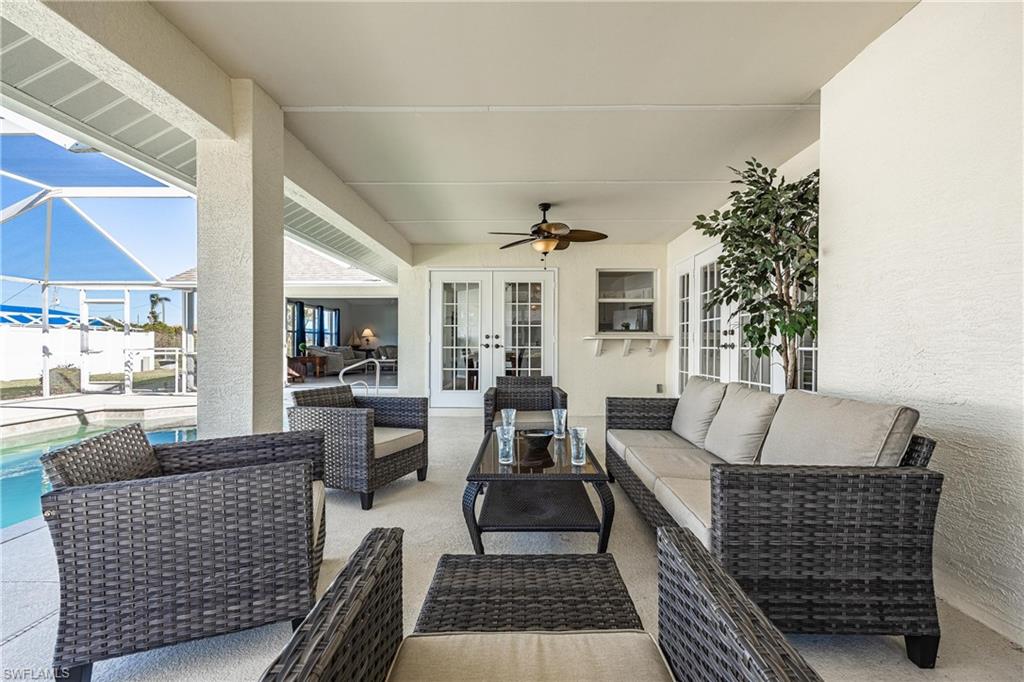 View of patio / terrace with french doors, a lanai, a ceiling fan, an outdoor hangout area, and an outdoor pool