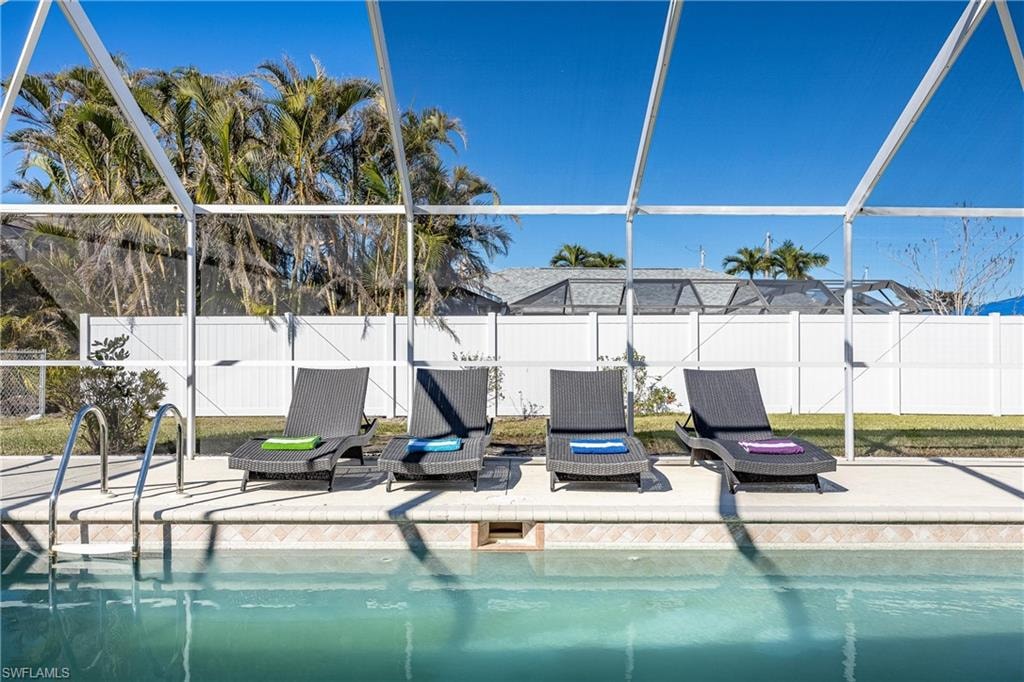 View of swimming pool with a lanai, a fenced backyard, a fenced in pool, and a patio