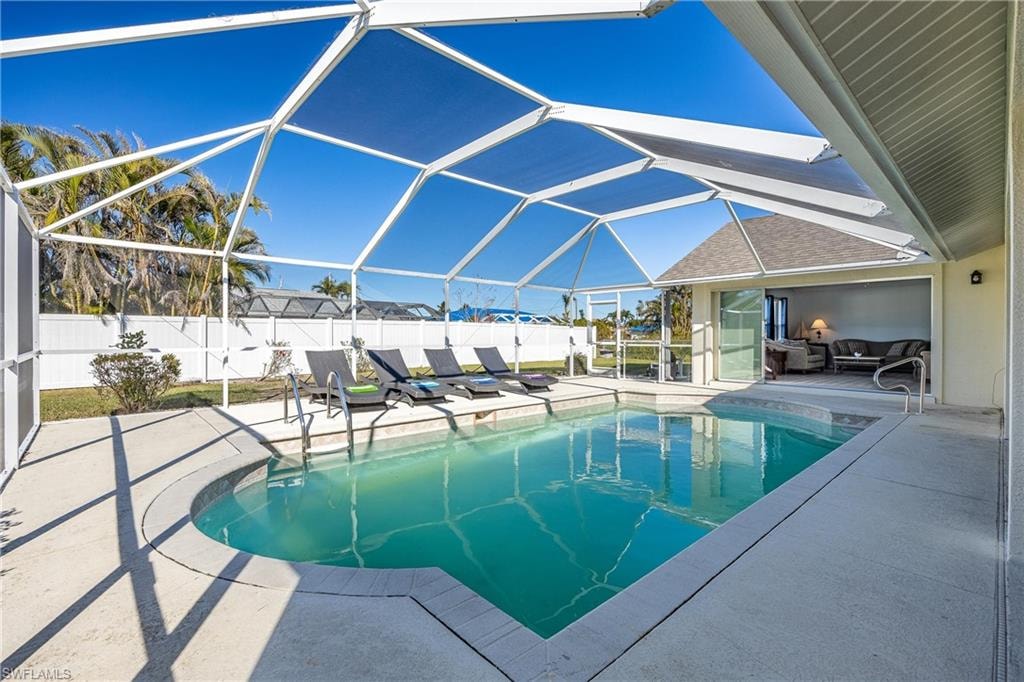 View of swimming pool with a patio area, a fenced in pool, and fence