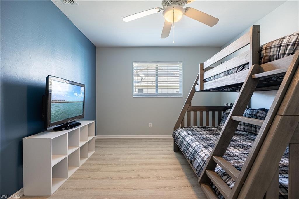 Bedroom with wood finished floors, a ceiling fan, and baseboards