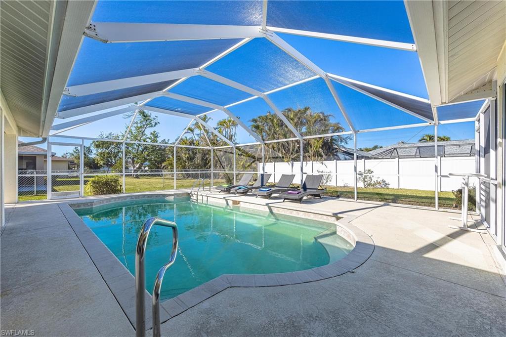 View of pool featuring fence, a patio area, a fenced in pool, and glass enclosure