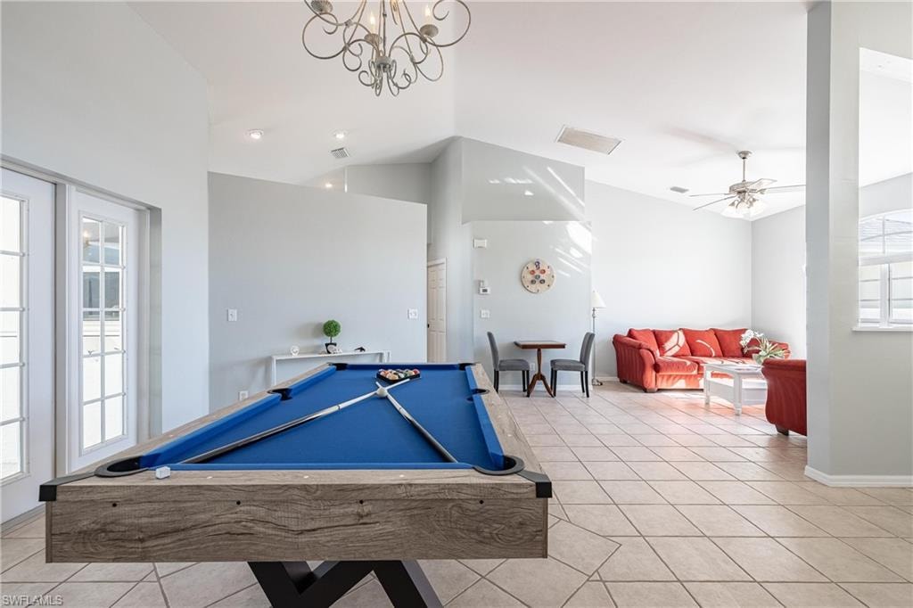Recreation room with pool table, light tile patterned floors, baseboards, lofted ceiling, and visible vents