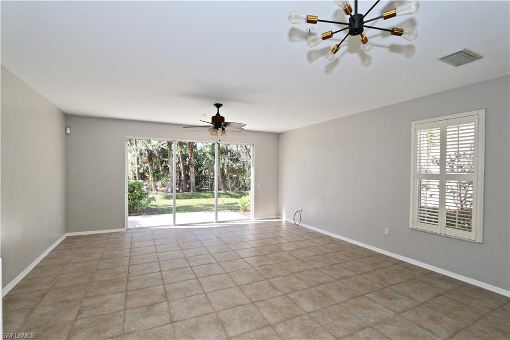 Spacious room featuring tile flooring, a contemporary ceiling light fixture, a ceiling fan, and sliding glass doors opening to the exterior