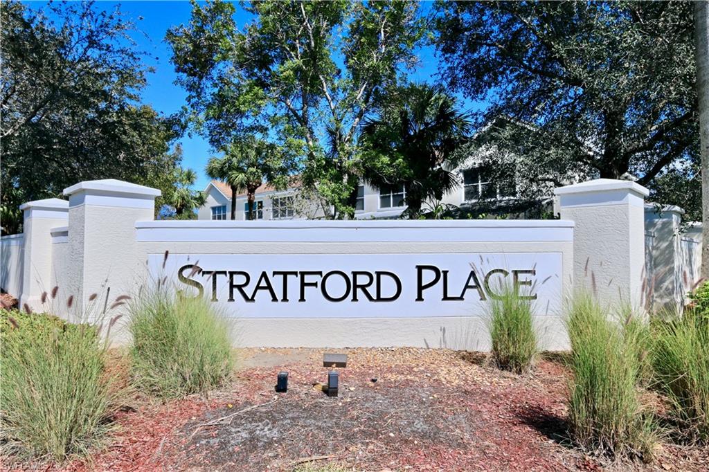 Entry monument with raised lettering and stucco finish, flanked by manicured landscaping