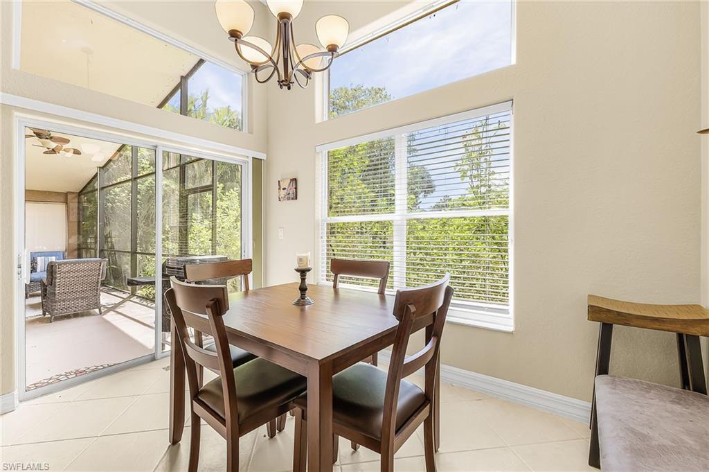 Vaulted ceilings with clerestory windows, screened patio with ceiling fan, sliding glass doors, and tile flooring