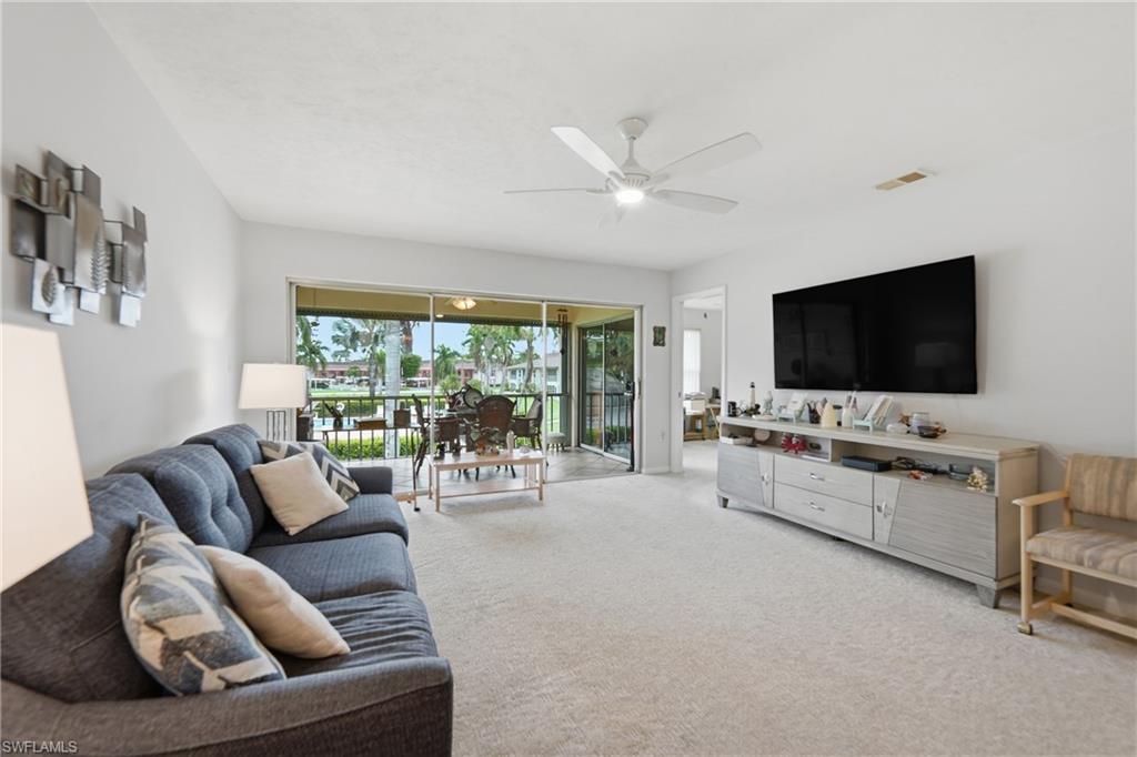 Bright living space with light-toned carpeting and a ceiling fan