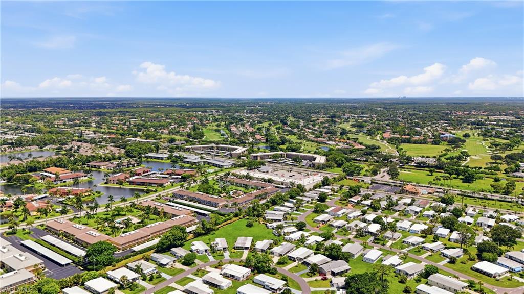 Aerial perspective showcasing residential developments, lush green spaces, and a prominent golf course