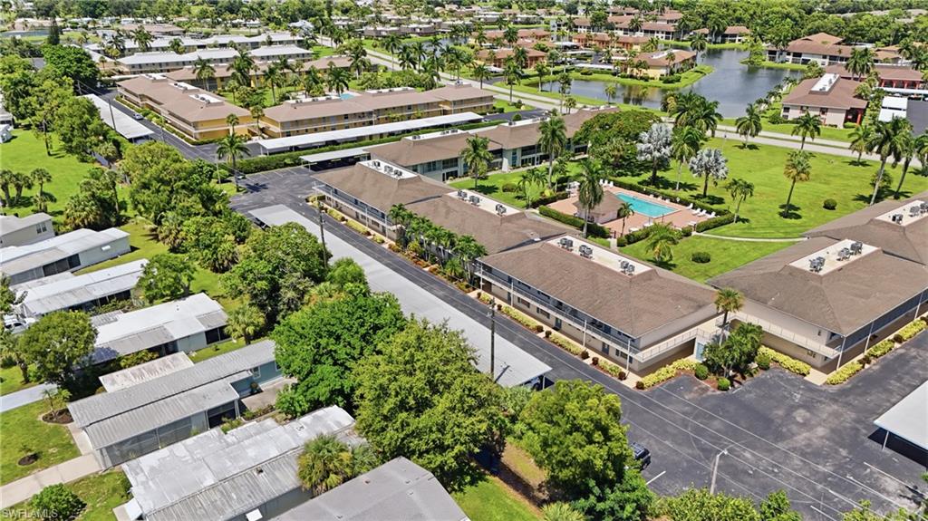 Community with multiple buildings, a swimming pool, and a pond