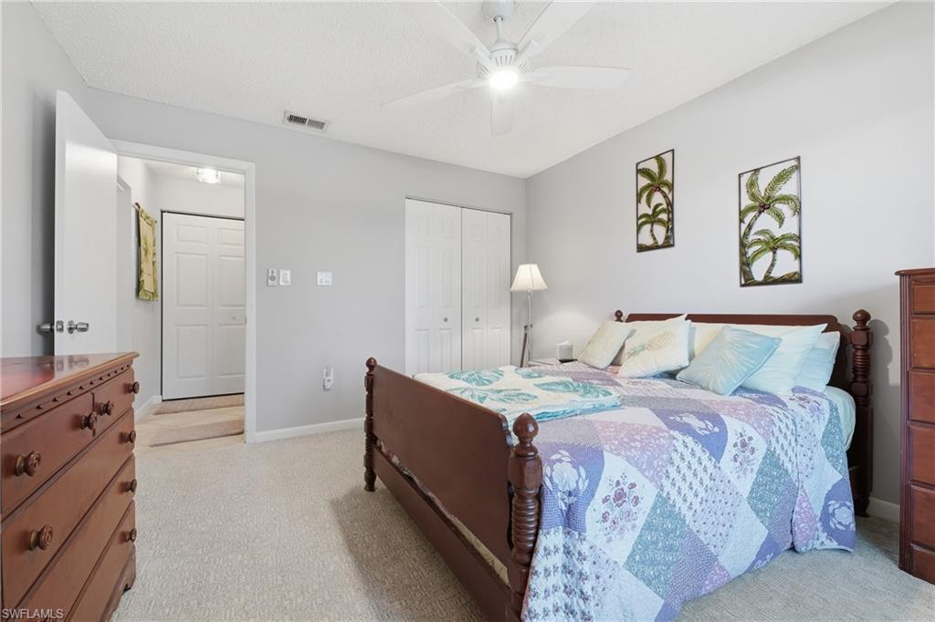 Wall-to-wall carpeting with light gray walls, white ceiling fan, and white bi-fold closet doors