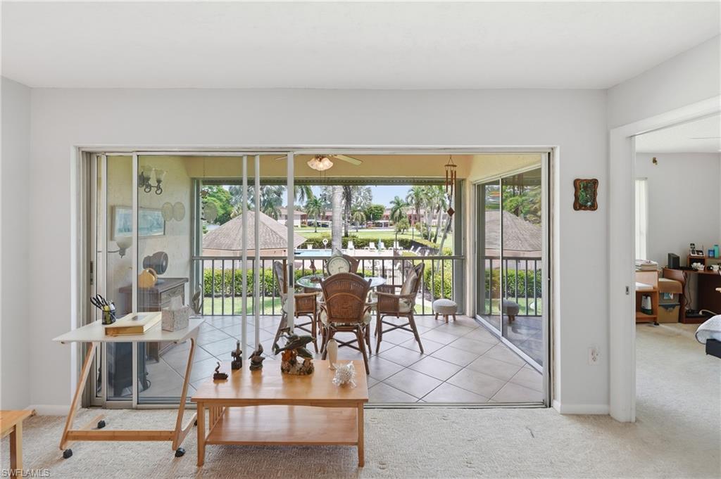 The living room opens wide to the glassed lanai and the courtyard beyond