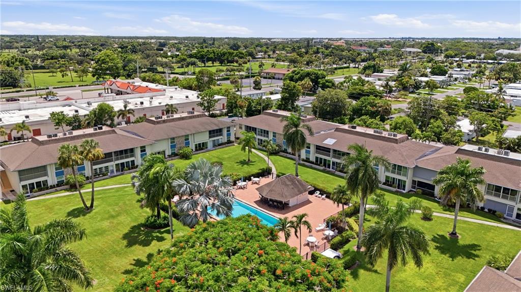 Expansive grounds featuring a community swimming pool, poolside cabana, and established palm trees