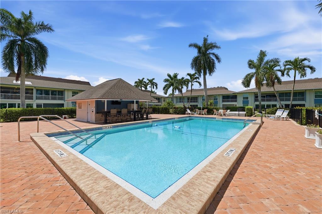 Community swimming pool with integrated steps, surrounded by brick paver decking
