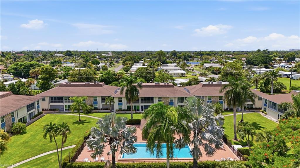 Expansive grounds featuring a swimming pool, surrounding patio, and mature palm trees