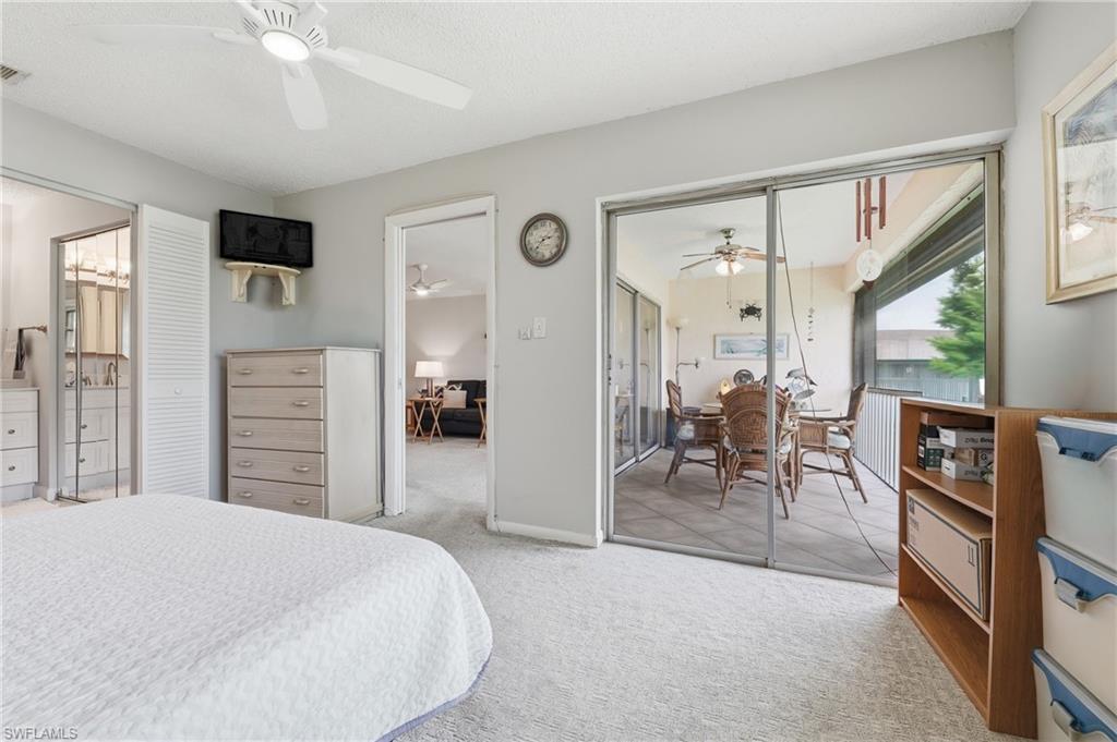 Carpeted flooring, ceiling fan, sliding glass doors, white louvered bifold closet doors, and recessed lighting in the adjacent bath