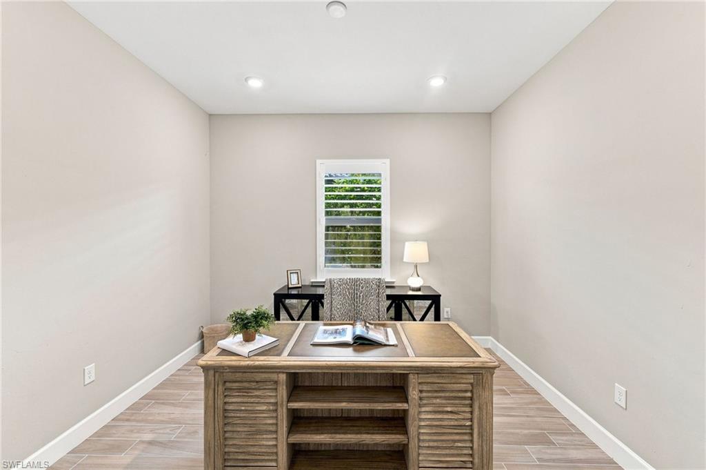 Den/ Office with recessed lighting, light-toned wall paint, tile flooring, white plantation shutters throughout the home