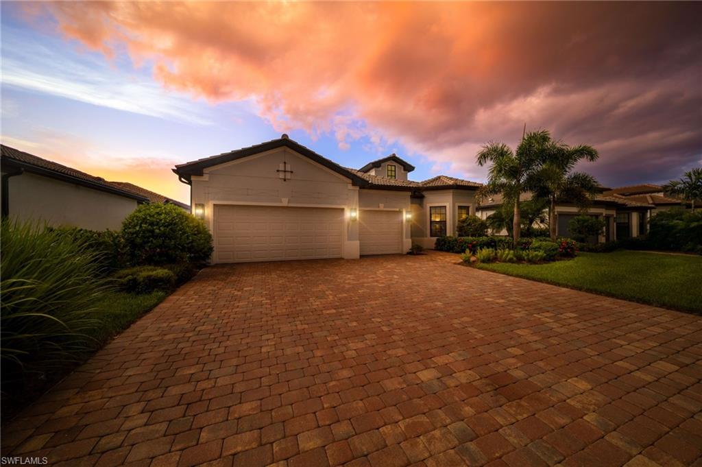 Brick paver driveway leading to a two-car garage