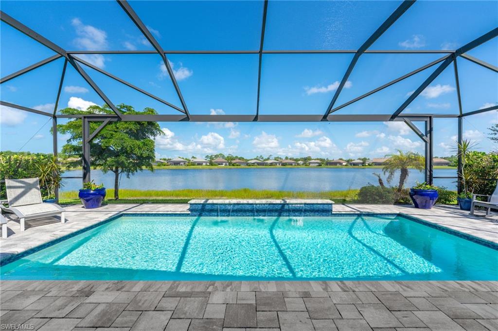 Screened-in outdoor living space with a clear views, salt -water swimming pool with waterfall feature