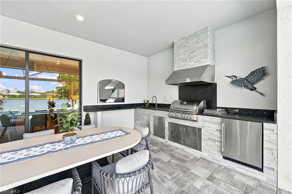 custom outdoor kitchen complete with gas grill, sink and beverage cooler