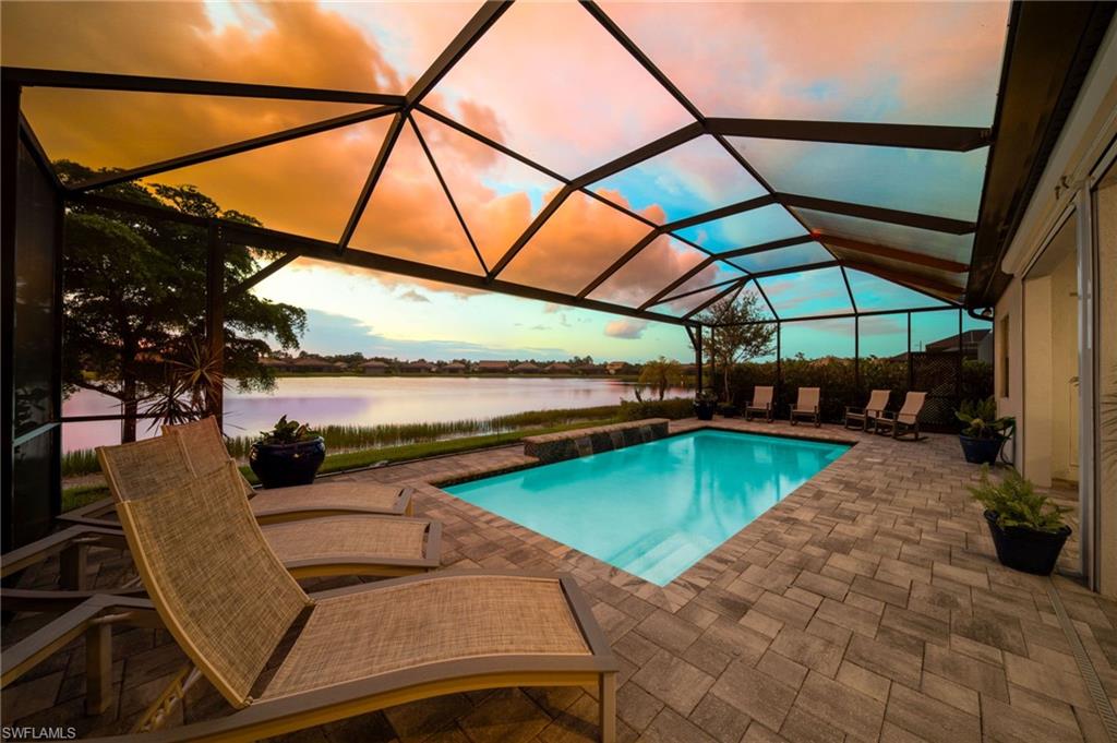 Screened lanai with frameless screen views , paver patio, saltwater pool with a water feature