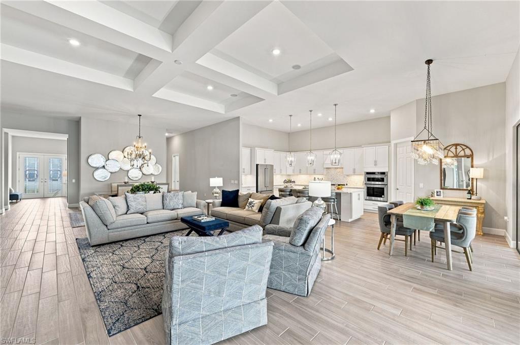 Open-concept living space featuring wood-tile flooring, recessed lighting, and coffered ceilings
