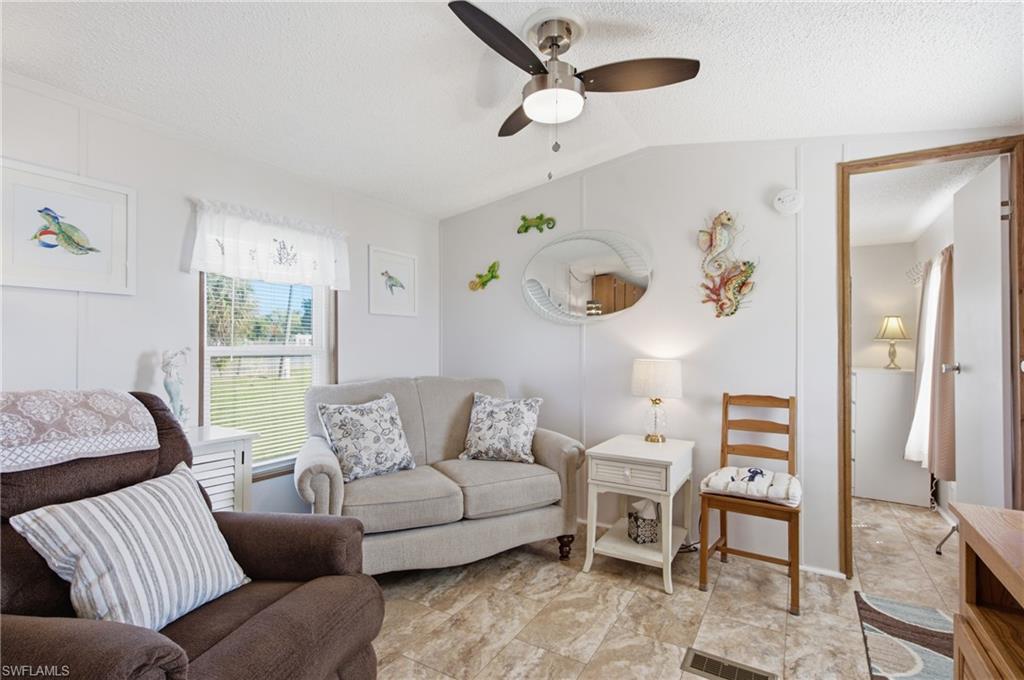 Recessed lighting with a ceiling fan, window with horizontal blinds, tiled flooring, and a white paneled wall