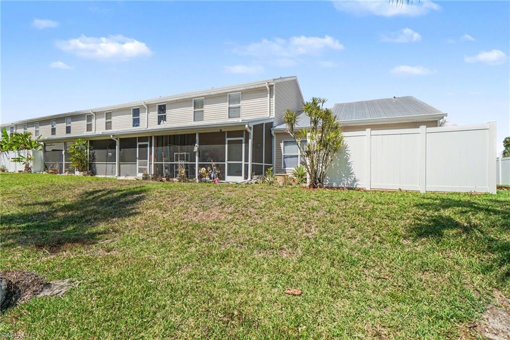 Manicured lawn with a white privacy fence and multiple screened-in porches