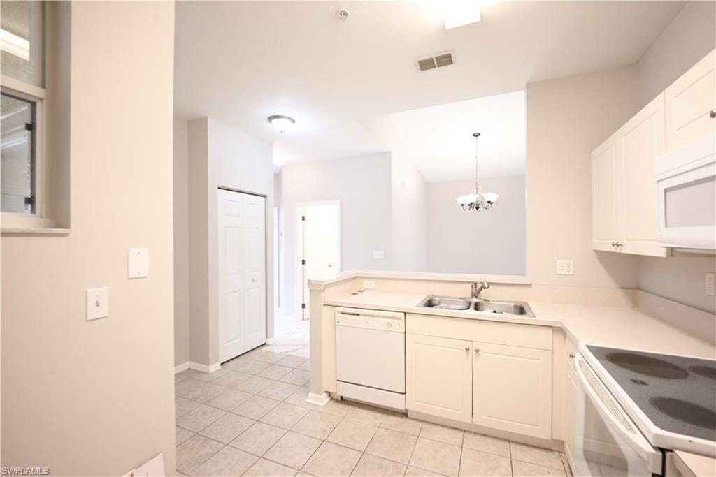Kitchen featuring white cabinetry, a double basin sink, white appliances, and tiled flooring