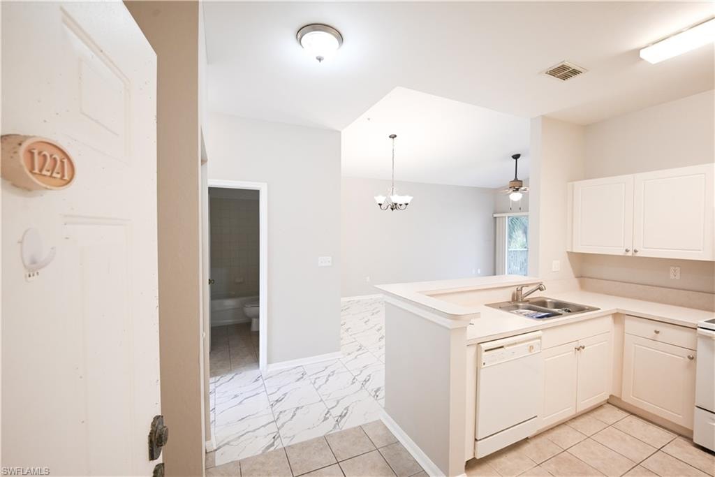 Kitchen featuring white cabinetry, a double basin sink, and a built-in dishwasher