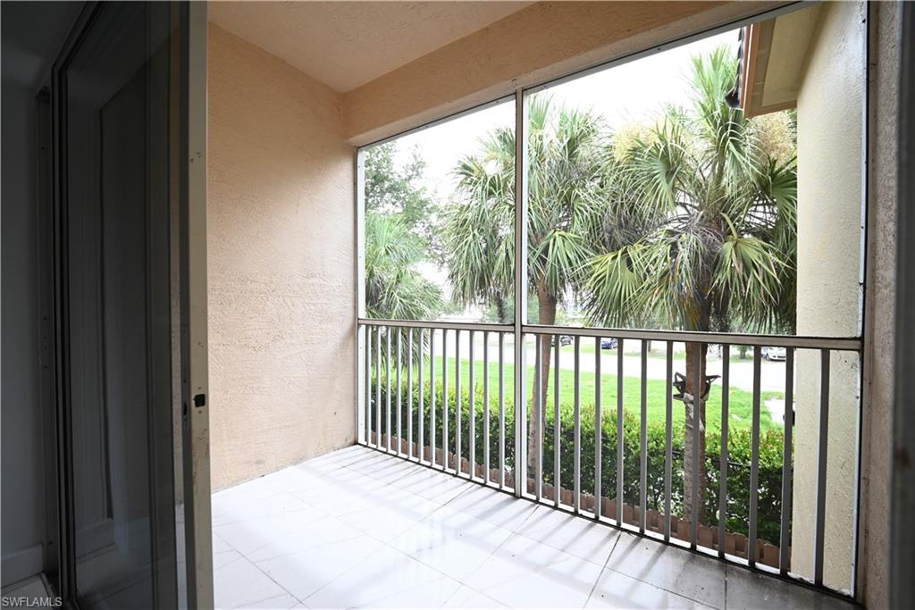Screened balcony with tile flooring and metal railing