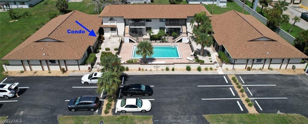 Community with a central swimming pool and surrounding paved patio